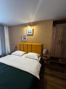 a bedroom with a large bed with a yellow headboard at Hostel Nomad in Tbilisi City