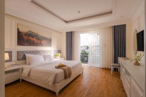 a bedroom with a large bed and a large window at Nature Hotel - Pham Hong Thai in Da Lat