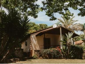 a small house with a garage in a garden at Klipspringer Lodge in Nelspruit