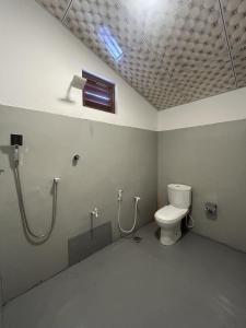 a bathroom with a toilet and a shower at Kora Beach House & Restaurant Cafe in Ampara +24 photos