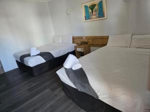 two beds in a small room with at Emerald Central Hotel in Emerald