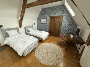 a bedroom with two beds and a table and a desk at Manoir de Cottentray Charming Manor in Avesnes-en-Bray