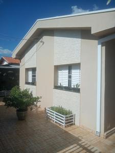 a white house with a window and a patio at Quarto Solteiro com TV in Artur Nogueira
