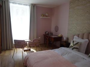 a bedroom with a bed and a desk and a window at Les Précieuses in Réaumur