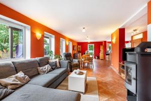 a living room with orange walls and a couch at Cattle Barn - leben auf dem Hof in Tröndel