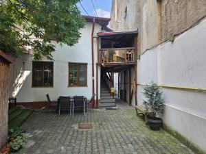 a building with a patio with a table and a balcony at HOSTEL SPORT BUCHAREST in Bucharest
