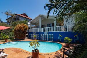 a swimming pool in front of a house at Blue Nautica Coastal Retreat in Ballito