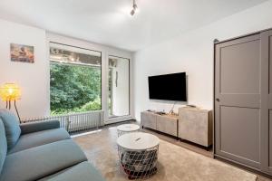 a living room with a blue couch and a tv at Apartment Maja in Winterberg