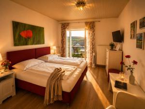 a bedroom with a large bed and a window at Mohnhotel - Bergwirt Schrammel in Zwettl Stadt