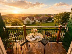a table and chairs on a balcony with the sunset at Mohnhotel - Bergwirt Schrammel in Zwettl Stadt +23 photos