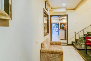 a living room with a chair and a staircase at Super Collection O Sindhi Camp Formerly Hotel Abhinandan Inn in Jaipur
