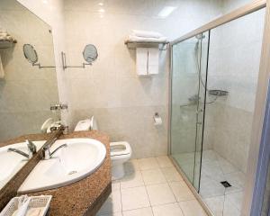a bathroom with a shower and a sink and a toilet at Hotel Nomu in Ulaanbaatar