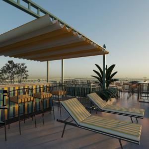 a patio with chairs and tables on a roof at Hôtel Le Joyau Bleu Hanoï in Hanoi