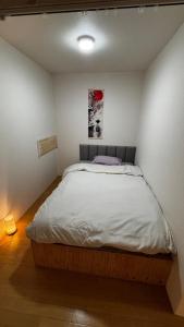 a bedroom with a large bed in a room at さくらやゲストハウス in Tokushima