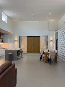 a large living room with a table and a kitchen at Kuraya Urban Space in Surabaya