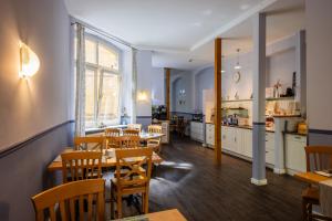 a restaurant with wooden tables and chairs and a kitchen at Boutique Hotel Schwarzer Baer in Lutherstadt Wittenberg