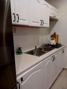 a kitchen with white cabinets and a sink at Apartament Deptak Sądecki in Nowy Sącz +11 photos