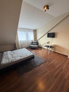 a bedroom with a bed and a chair and a desk at N90 Living in Karlsruhe