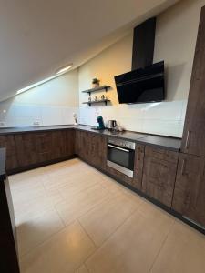 a large kitchen with a stove and a tv at N90 Living in Karlsruhe