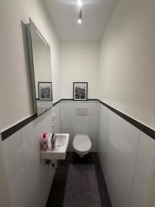 a bathroom with a white toilet and a sink at N90 Living in Karlsruhe