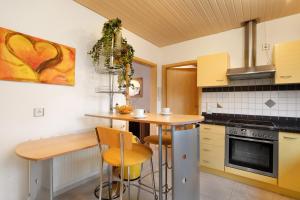a kitchen with a counter and a table and chairs at Sandra in Berghülen