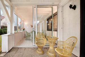 a porch with wicker chairs and a table at Sandra in Berghülen +17 photos
