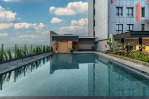 a swimming pool in front of a building at FOX Lite Hotel Majalaya in Bojong