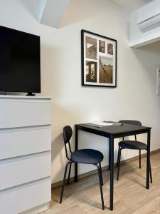 a black desk with a chair and a television at Penzion Klas in Měřín