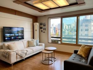 a living room with a couch and a tv at BV House in Incheon