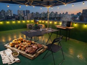 a table and chairs with a buffet of food on a rooftop at BV House in Incheon