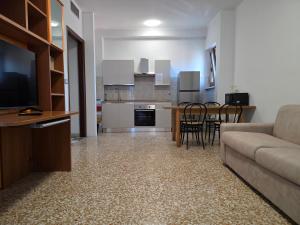 a living room and kitchen with a couch and a table at Da Silvia ampio appartamento metro Paradiso in Collegno