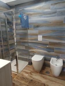 a bathroom with a toilet and a glass shower at Antiche Torri Guest House in Castel Volturno