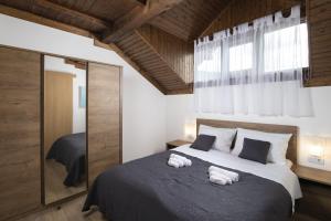 a bedroom with a large bed with towels on it at Mountain Escape house with indoor pool in Fužine