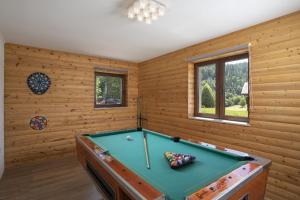 a pool table in a room with wooden walls at Mountain Escape house with indoor pool in Fužine