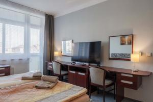 a hotel room with a desk and a television at Hotel Morava Jevíčko in Jevíčko