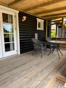 a wooden deck with a table and chairs on it at Bøtøstrand anneks in Bøtø By