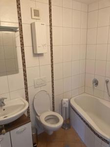a bathroom with a toilet and a tub and a sink at Evelyn in Emmelshausen