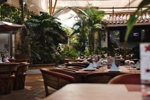 a restaurant with tables and chairs and plants at Villa Bonita Les Terrasses in Cuernavaca