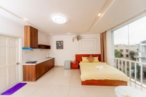a bedroom with a bed and a kitchen with a window at New Sun Hotel in Da Lat