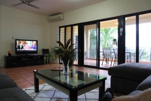 a living room with a coffee table and a television at Darwin Deluxe Apartments in Darwin