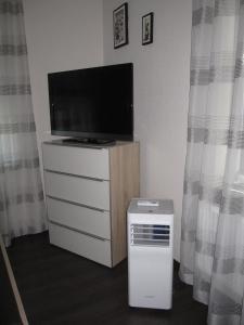 a living room with a television and a unit with a heater at Am Living Garden in Bad Pyrmont