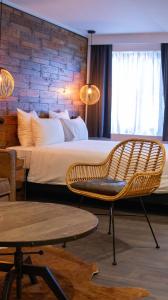 a bedroom with a bed and a chair and a table at Hotel Brouwerij Het Anker in Mechelen +53 photos