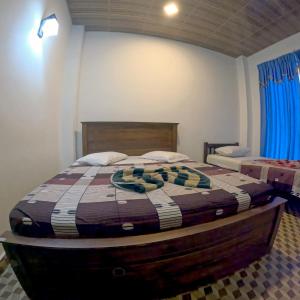 a bedroom with a bed with a wooden head board at VRK Adventure Basecamp Sri Lanka in Kitulgala +15 photos