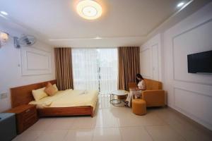 a woman sitting in a chair in a bedroom at New Sun Hotel in Da Lat