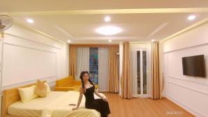 a woman sitting on a bed in a hotel room at New Sun Hotel in Da Lat +7 photos