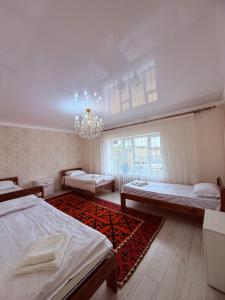a large room with two beds and a chandelier at Erkaiym Guest house in Bokonbayevo
