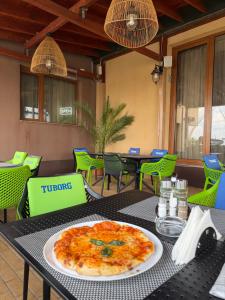 a pizza sitting on top of a black table at Hotel Hanul de la Rascruce in Arad