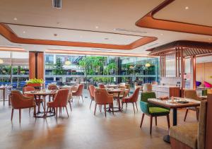 a restaurant with tables and chairs and windows at FUGO Hotel Banjarmasin in Banjarmasin