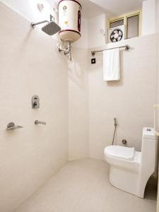 a white bathroom with a toilet and a shower at Hariom Stay Rishikesh in Rishīkesh