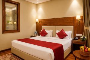 a hotel room with a large bed with red pillows at The Rosendale Srinagar in Srinagar +14 photos